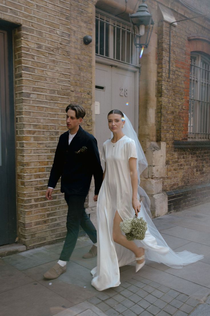 a bride and groom walking down the street