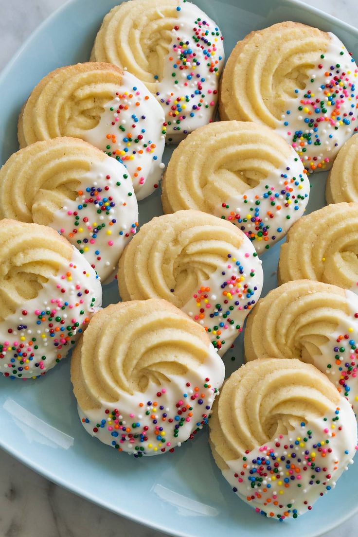 several frosted donuts with sprinkles on a plate