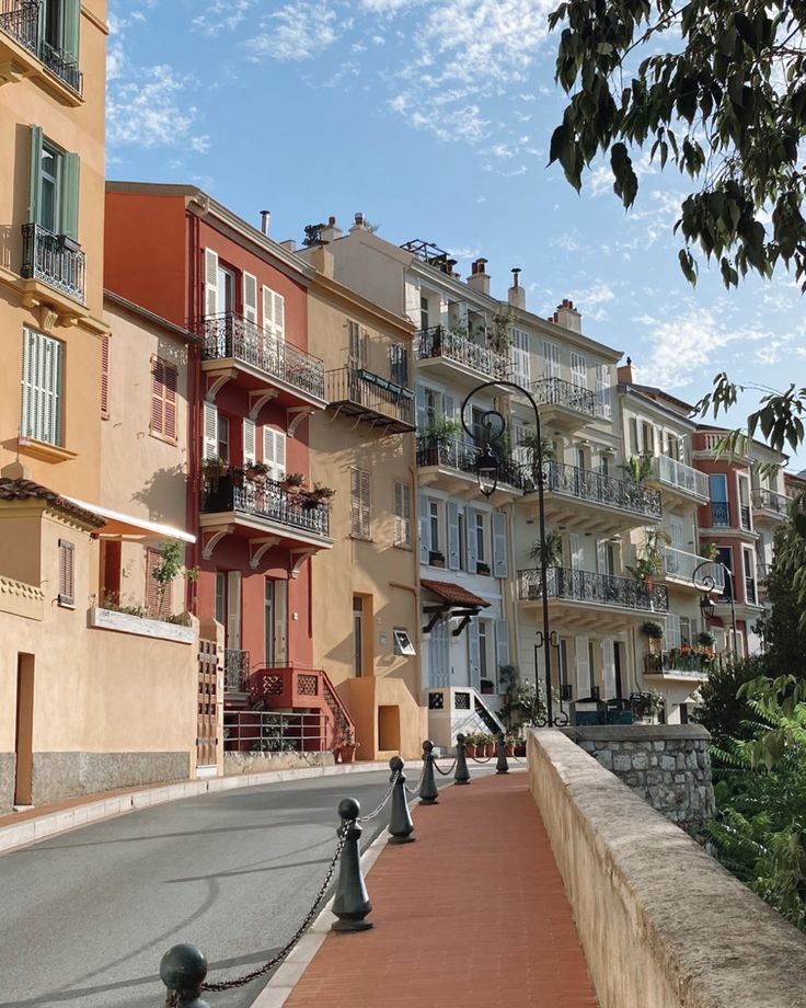 an empty street lined with multi - colored buildings and balconies on either side