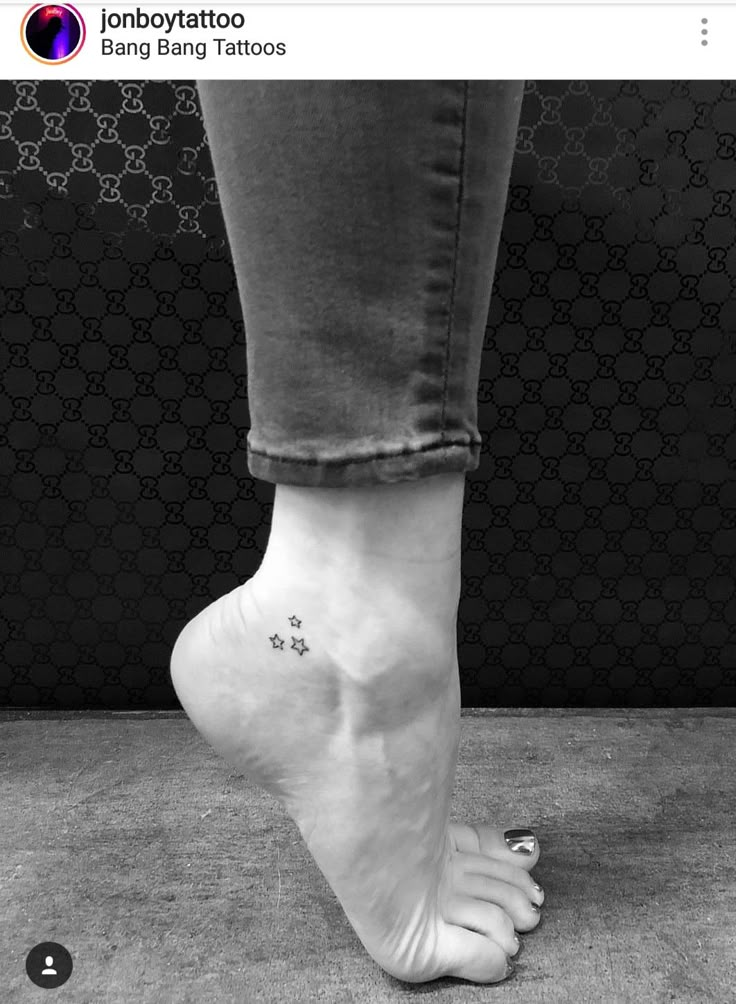 a woman's foot with a small star tattoo on it