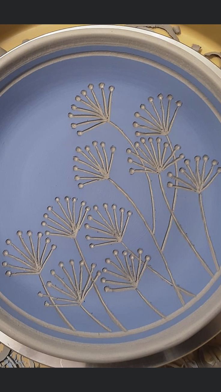 a blue plate with silver designs on it