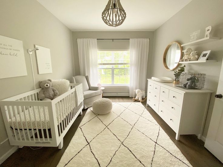 a baby's room with a crib, dressers and a large window