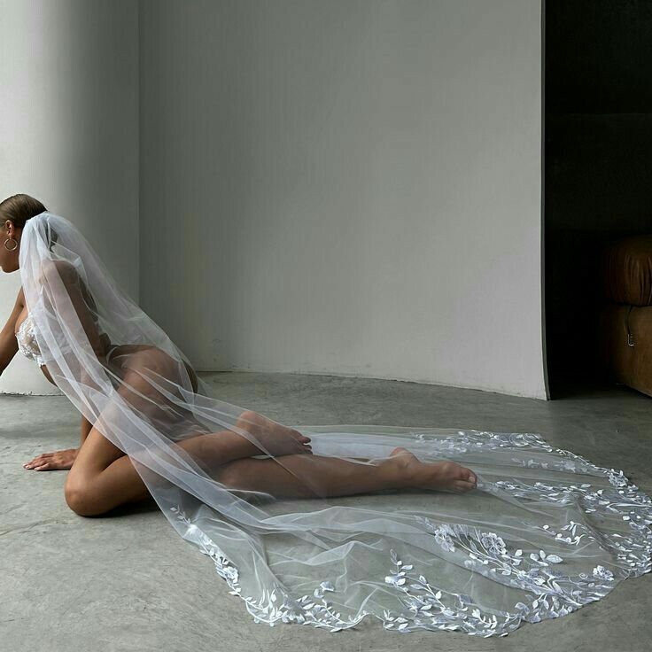 a woman sitting on the floor wearing a veil