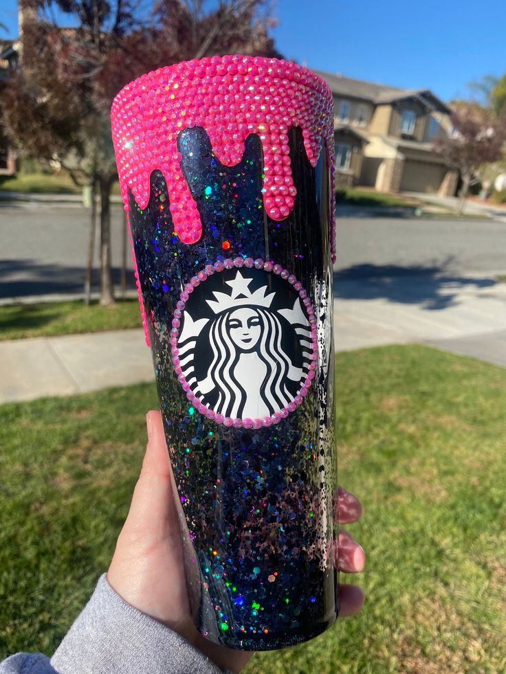 someone holding up a starbucks cup with pink and blue sprinkles on it