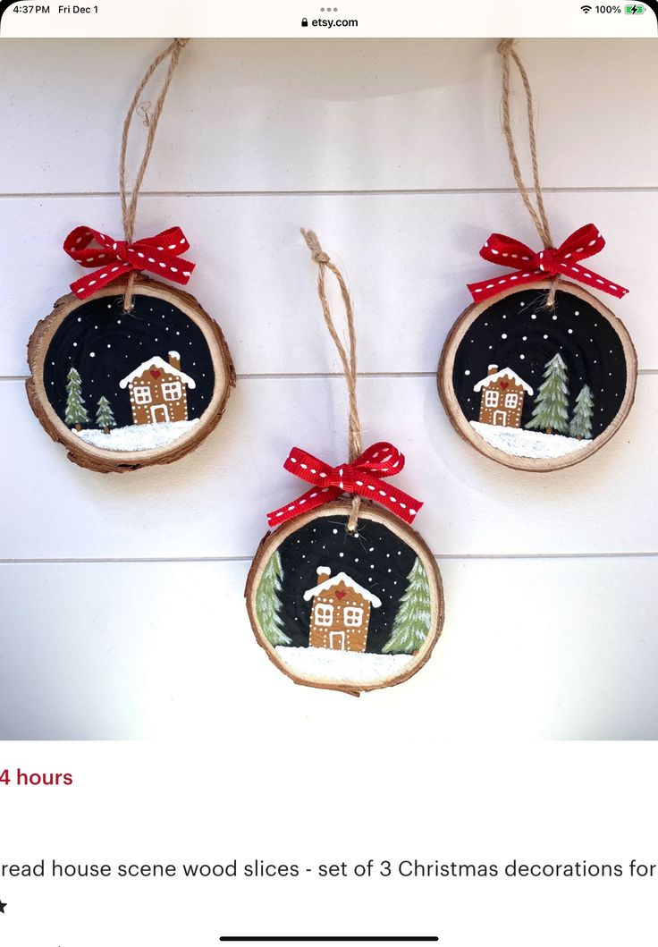 two christmas ornaments hanging on the wall with red bows and ribbon around them, decorated with houses