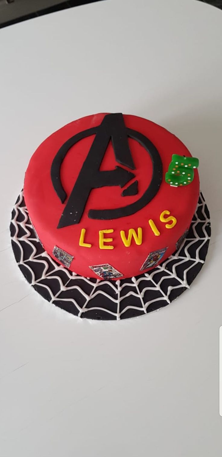 a red cake with black icing and the letter a is for lewis on it