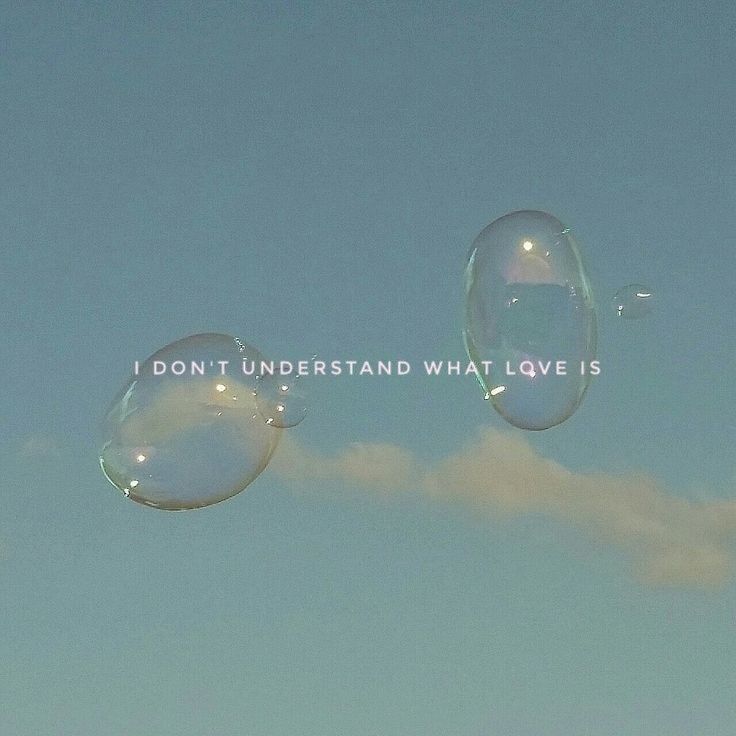 two soap bubbles floating in the air with a message written on them that reads, i don't understand what love is