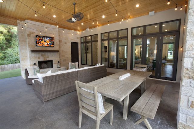 an outdoor living area with patio furniture and string lights