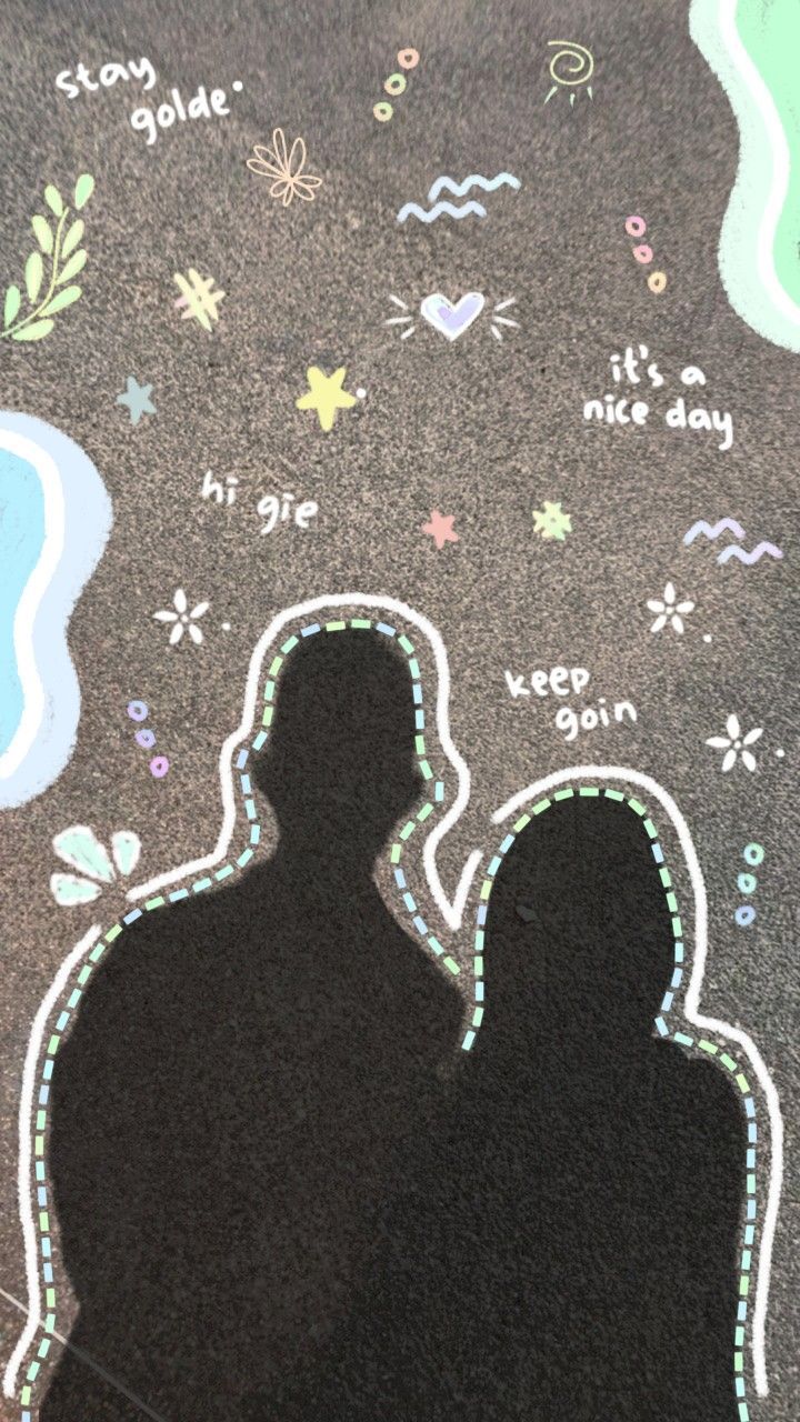 the shadow of a man and woman in front of a chalk drawing