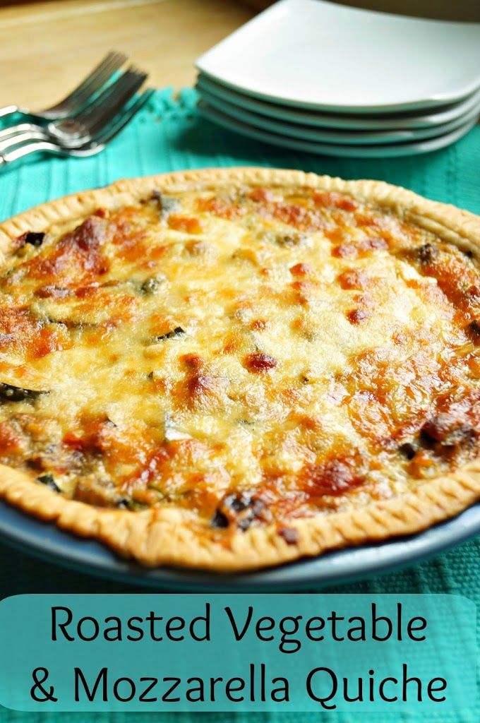 roasted vegetable and mozzarella quiche on a blue plate with silverware in the background