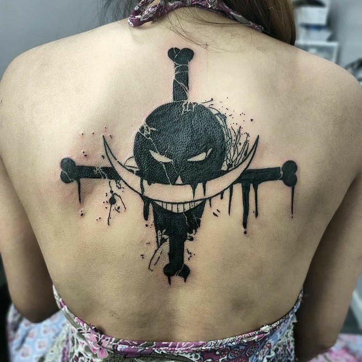 the back of a woman's shoulder with a black and white tattoo design on it