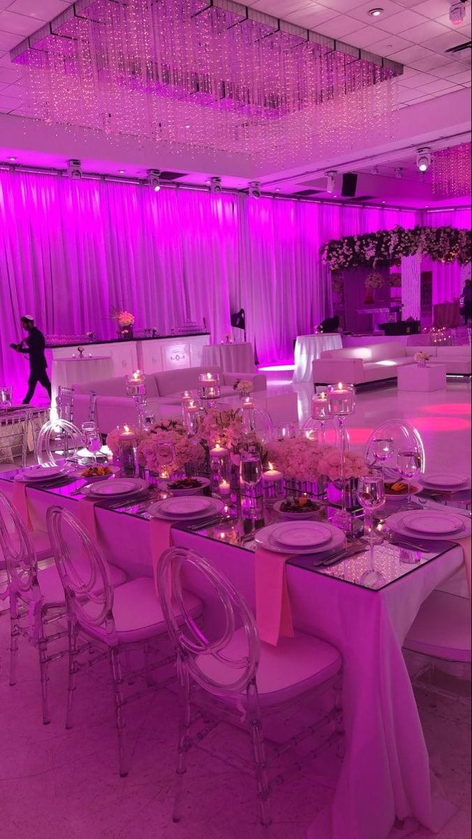 a dining room set up for a party with purple lighting