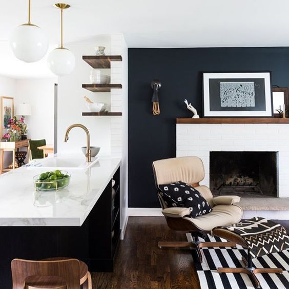 a living room filled with furniture and a fire place in the middle of a kitchen