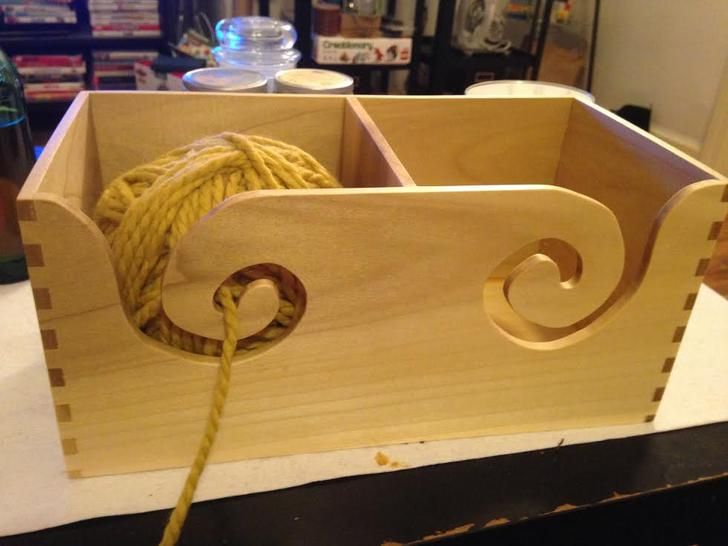 a close up of a rope in a wooden box on a table with other items