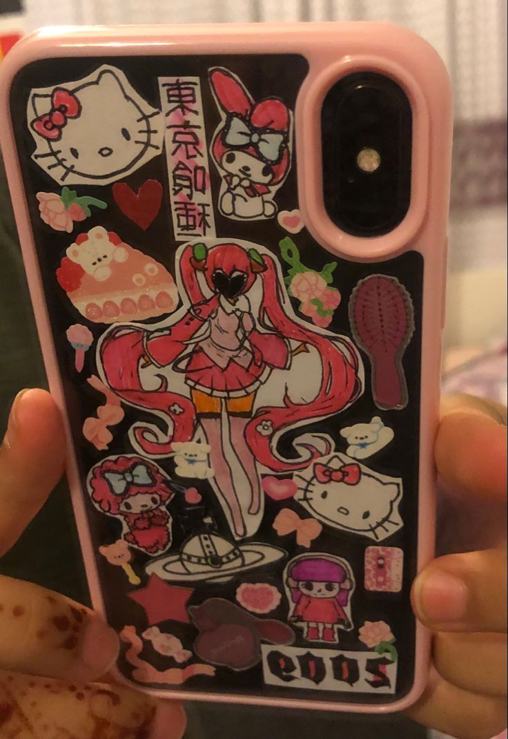 someone is holding up their phone case with hello kitty stickers all over the back