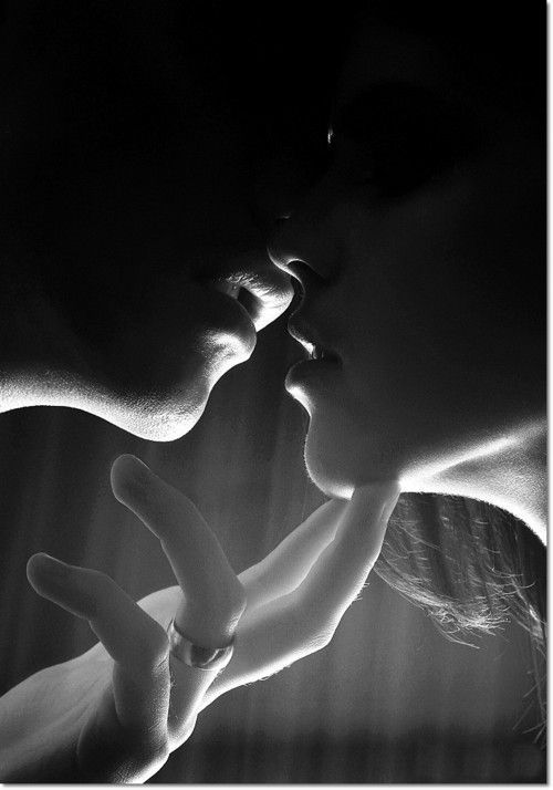 a man and woman kissing each other in front of a dark background with the word love written on it