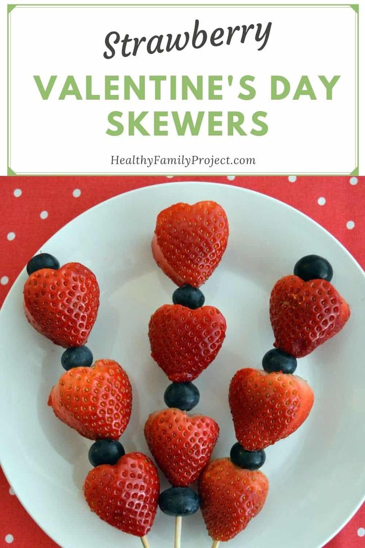 strawberries and blueberries on a white plate with the words strawberry valentine's day skewers