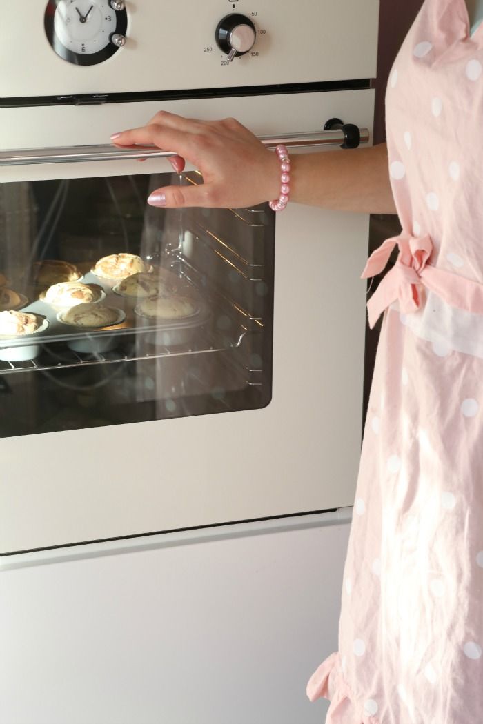 a woman is taking food out of an oven