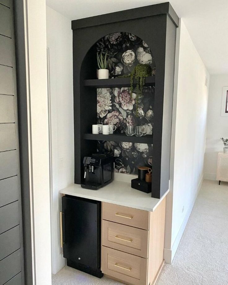 a black and white shelf with flowers on it in a room next to a door