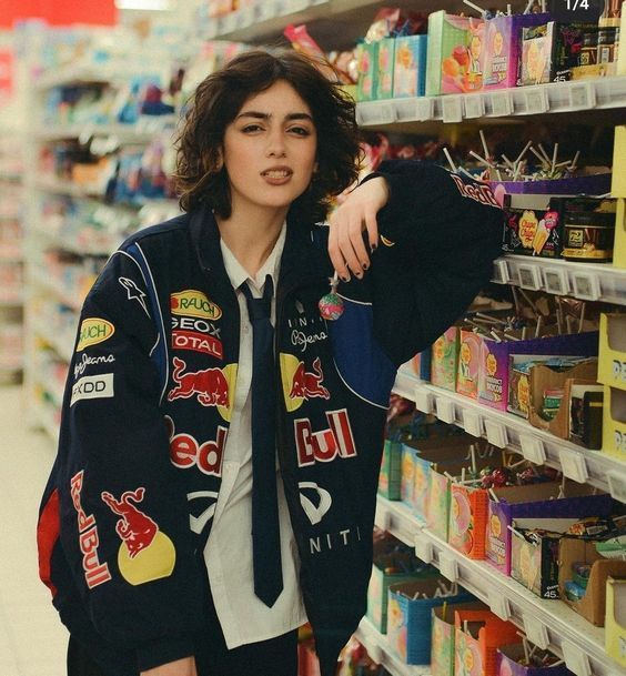 a woman standing in front of a store shelf with her hand on her hip and looking at the camera