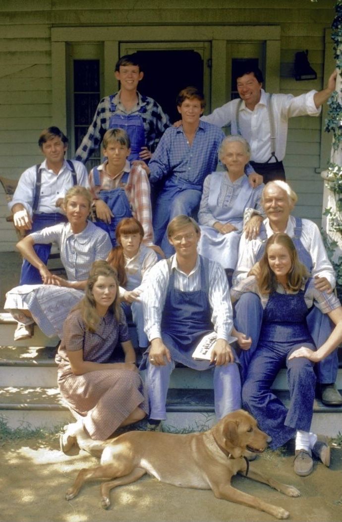 a group of people and a dog pose for a photo on the front steps of a house