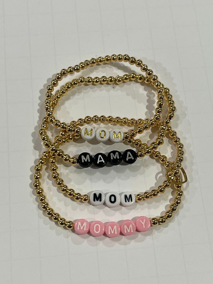 Set Of Mom, Mama or Mommy Bracelets (3 in each order)  14K Gold Plated - Must wear with care/avoid water and oil  14K Gold Filled - Nontarnishable gold beads  Word Choice: Mom, Mama, or Mommy Color: Black, White, Pink, Gold, or Red PLEASE DESCRIBE THE COLOR, COLORS, OR PATTERN YOU WANT IN THE PERSONALIZATION OPTION OR ORDER NOTES  Bead Options:  14K Gold Plated - Must wear with care/avoid water and oil  14K Gold Filled - Nontarnishable gold beads  CARE To prolong the life of your jewelry, please follow recommendations stated. To prevent excess stretching, wear and tear, we suggest rolling the bracelet down your hand onto your wrist. If you choose Gold or Silver Beads - please note that these beads are plated and if improperly cared for, they will tarnish or fade. This means no scraping, ex Gold Name Bracelet As Gift For Mom, Gold Bracelet Jewelry As Gift For Mom, Adjustable Gold Beaded Bracelets As Gift For Mom, Adjustable Gold Beaded Bracelet As A Gift For Mom, Gold Beaded Bracelets For Mother's Day Gift, Gold Charm Bracelet For Mom On Mother's Day, Mother's Day Gold Charm Bracelet For Mom, Gold Bracelet With Letter Beads As Gift For Mom, Gold Name Bracelet With Letter Beads For Mother's Day