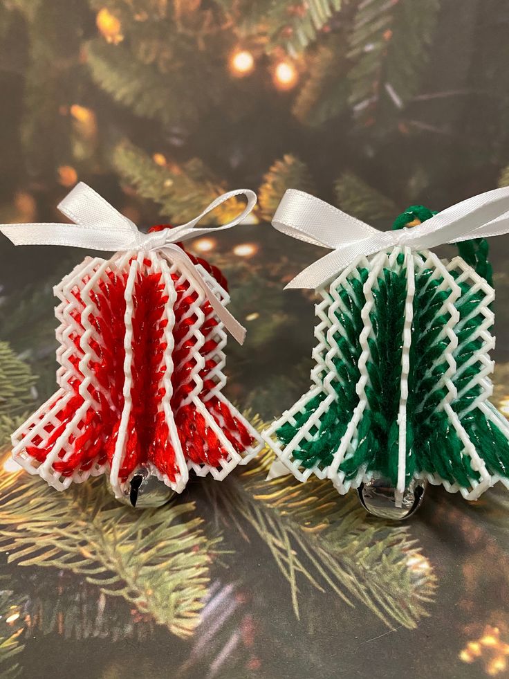 two small christmas trees made out of yarn on top of a table next to a christmas tree