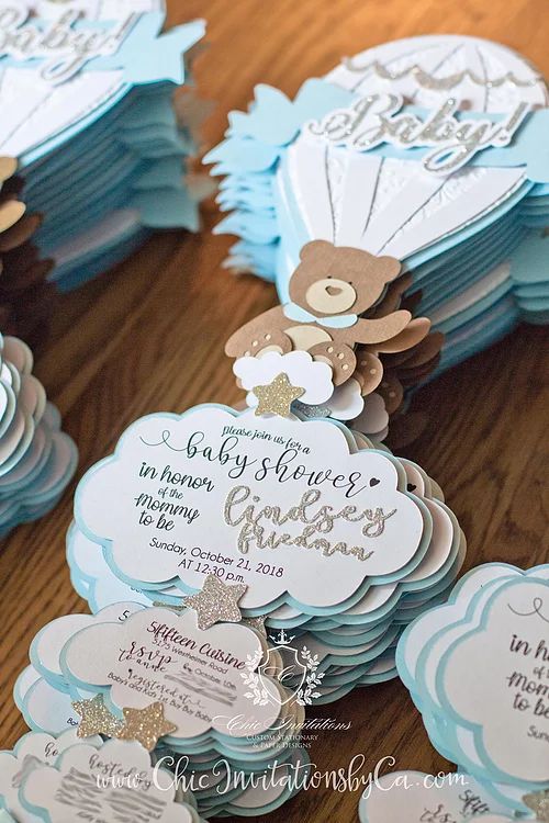 blue and white baby shower favors with teddy bears on them, sitting on a wooden table