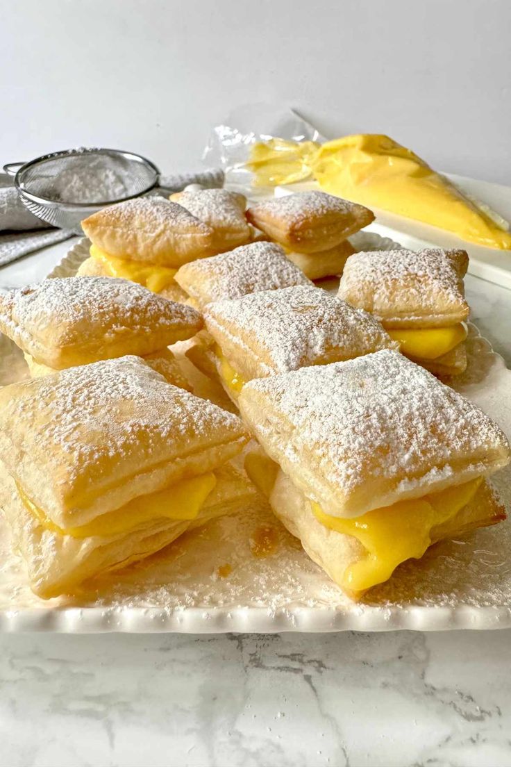 powdered sugar covered pastries on a white plate