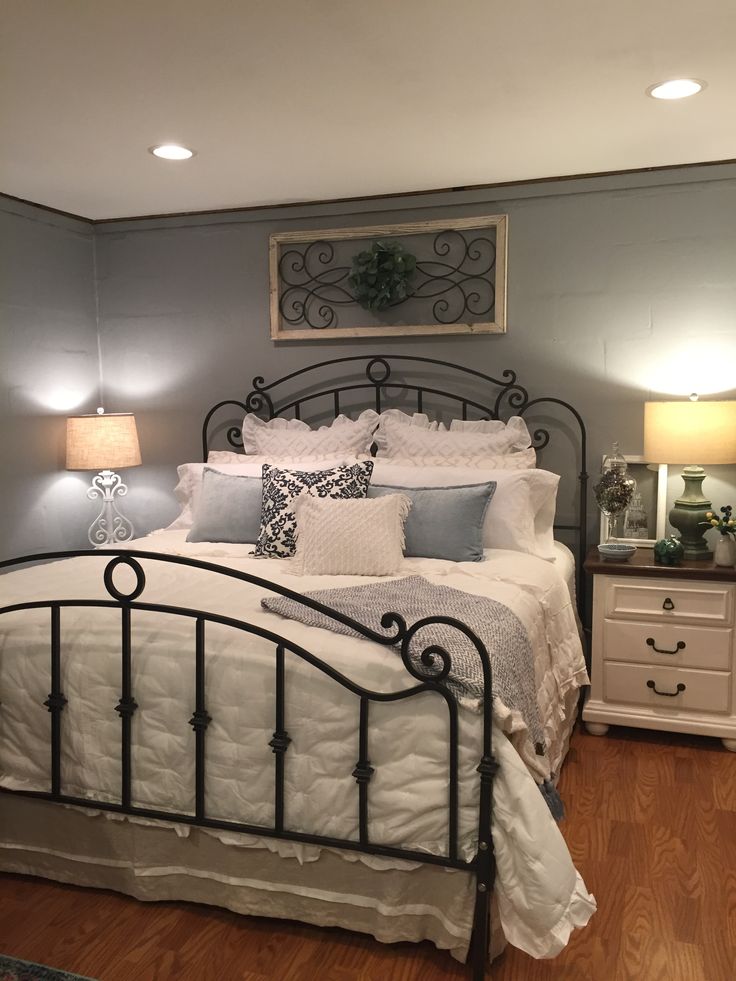 a bedroom with a bed, nightstands and two lamps on either side of the bed