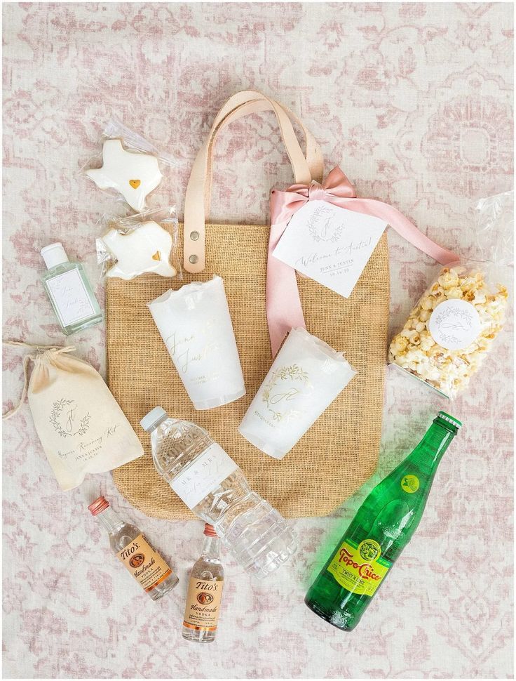 an assortment of personal care items laid out on top of a bed with pink and white wallpaper