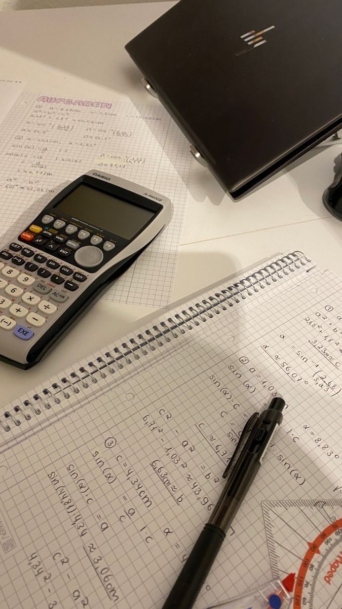 a calculator sitting on top of a table next to a pen and paper