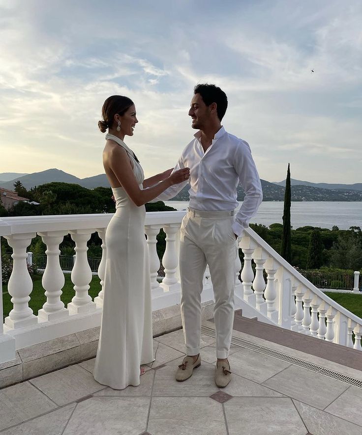 a man and woman standing next to each other on a balcony