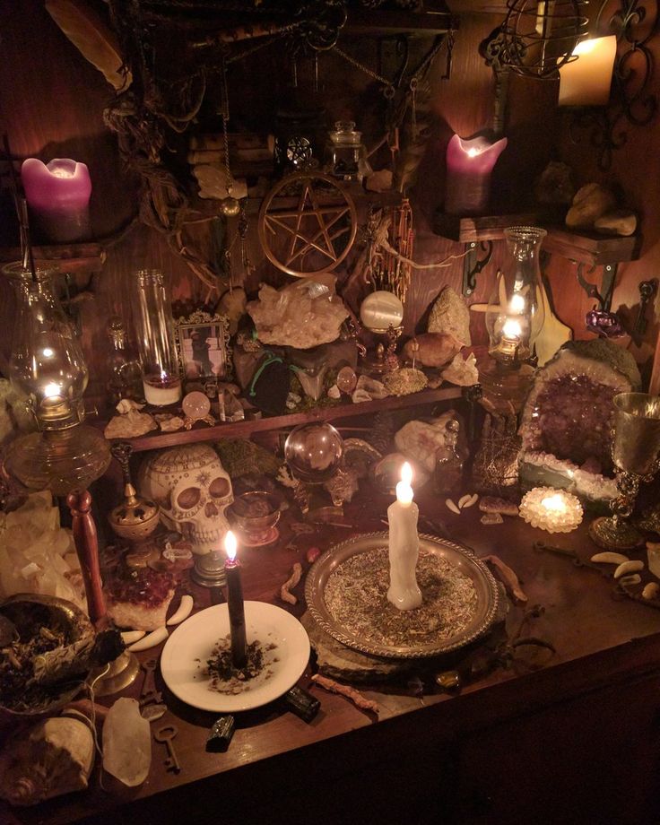 a table topped with lots of candles next to skulls and other items on top of it