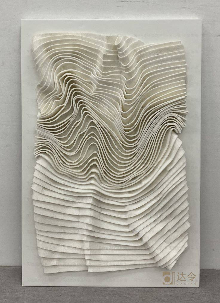 an art piece made out of folded paper with wavy lines on the bottom and sides