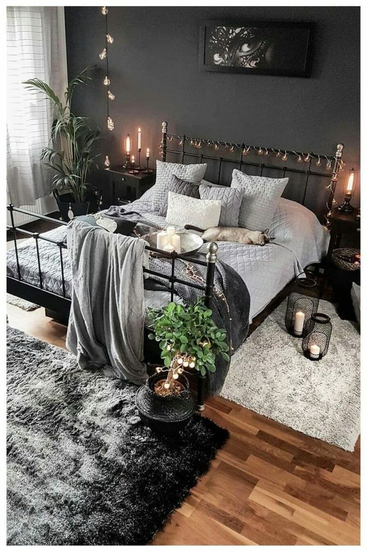 a bed room with a neatly made bed and candles