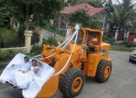 two men in white robes are sitting on a large tractor with a sheet draped over it