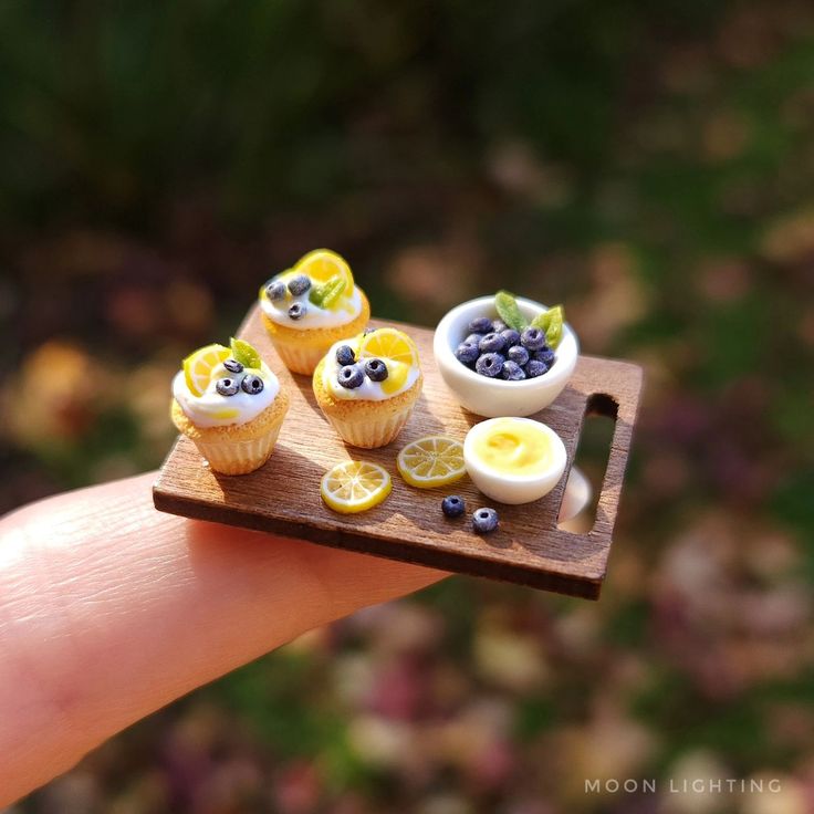 miniature cupcakes with blueberries and lemon slices on a wooden tray