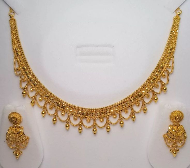 a gold necklace and earring set on display