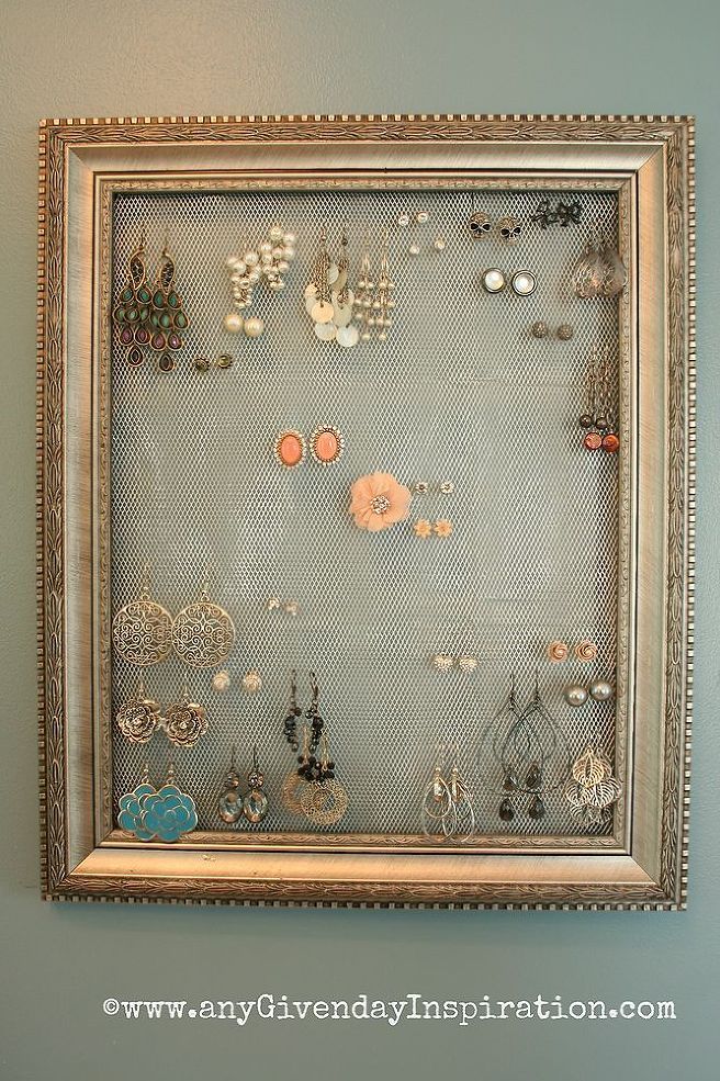 an old frame with earrings hanging on the wall