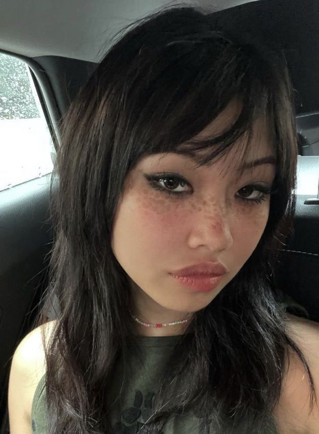 a woman with freckles on her face sitting in a car