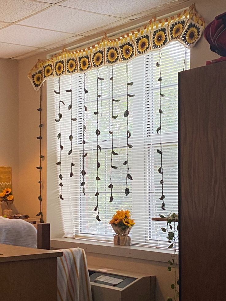 a bedroom with sunflowers and curtains in the window