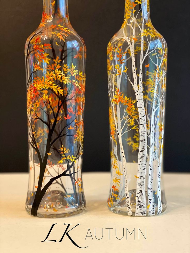 two glass vases with trees painted on them