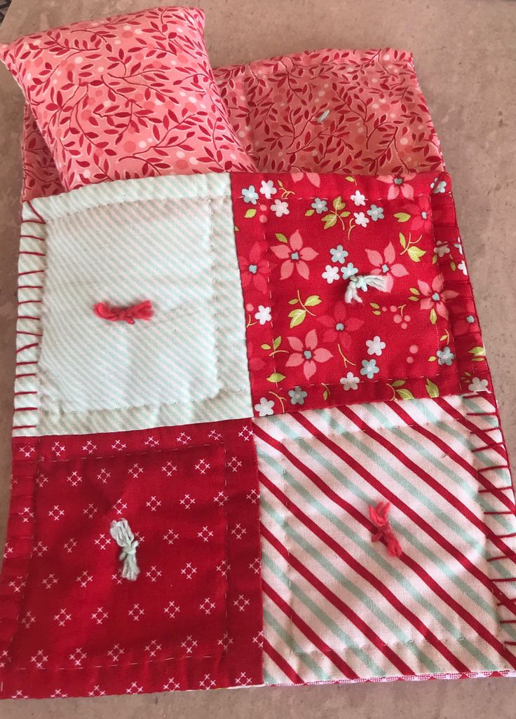 the red and white quilt is laying on the floor