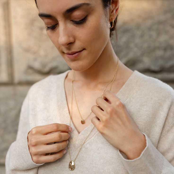 The Precious Pebble Necklace is the sister to our cherished Worry Stone Necklace. Designed to harness the grounding power of touch, this necklace invites you to hold, touch, and rub it, providing a precious moment to yourself. Suspended on a 20" chain, it effortlessly layers with the Worry Stone Necklace for a versatile, harmonies look. Hand-poured and intentionally unpolished, each necklace boasts a one-of-a-kind texture, celebrating the beauty of uniqueness. Spiritual Everyday Necklace That Is Tarnish Resistant, Spiritual Everyday Necklace Tarnish Resistant, Everyday Teardrop Cable Chain Jewelry, Necklace With Cable Chain And Round Pendant For Layering, Minimalist Teardrop Cable Chain Necklaces, Minimalist Teardrop Cable Chain Necklace, Minimalist Teardrop Necklace With Cable Chain, Cable Chain Necklace With Round Pendant For Layering, Oval Recycled Gold Necklace For Gift