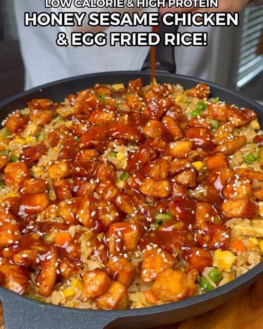 someone is pouring sauce on some chicken in a skillet with the words low carb & high protein honey sesame chicken and egg fried rice