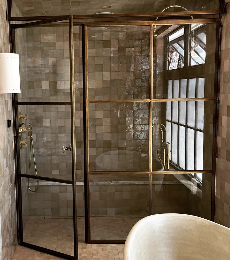 a bath tub sitting under a window next to a shower head mounted faucet