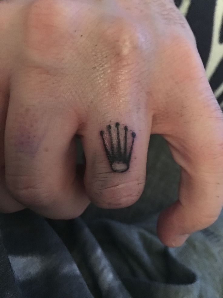 a hand with a crown tattoo on it