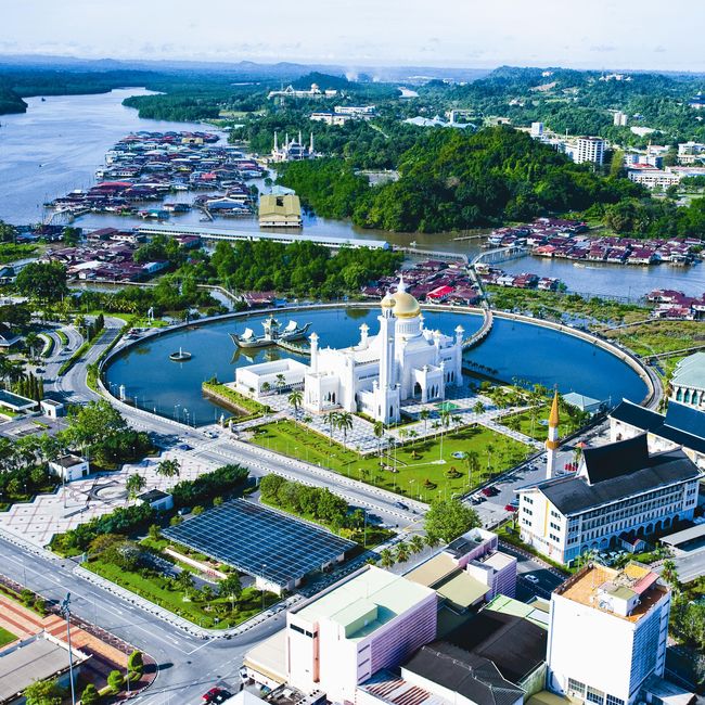 an aerial view of a city with lots of buildings and water in the background,