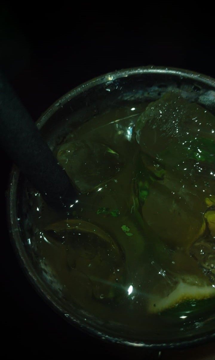 a cup filled with green liquid on top of a table